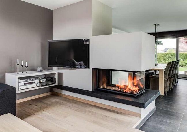 Moderner Wohnraum mit Wand-TV, Kaminfront mit Flammen und Esstisch im Hintergrund.