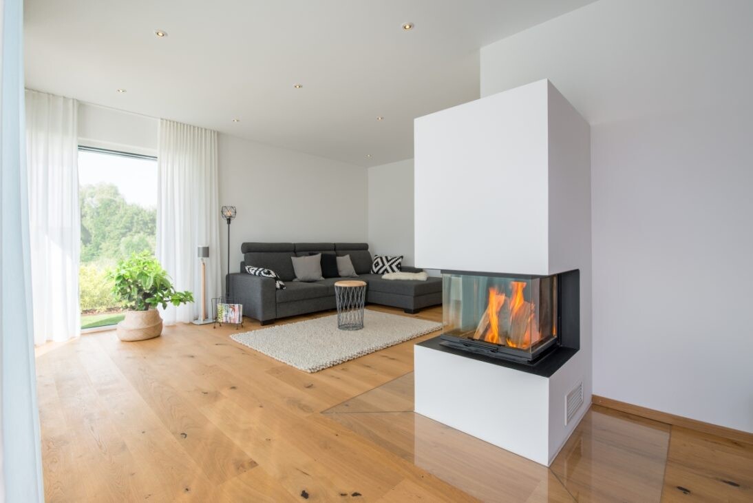 Modernes Wohnzimmer mit Kamin, graue Eckcouch, heller Holzboden, große Fensterfront, Pflanze