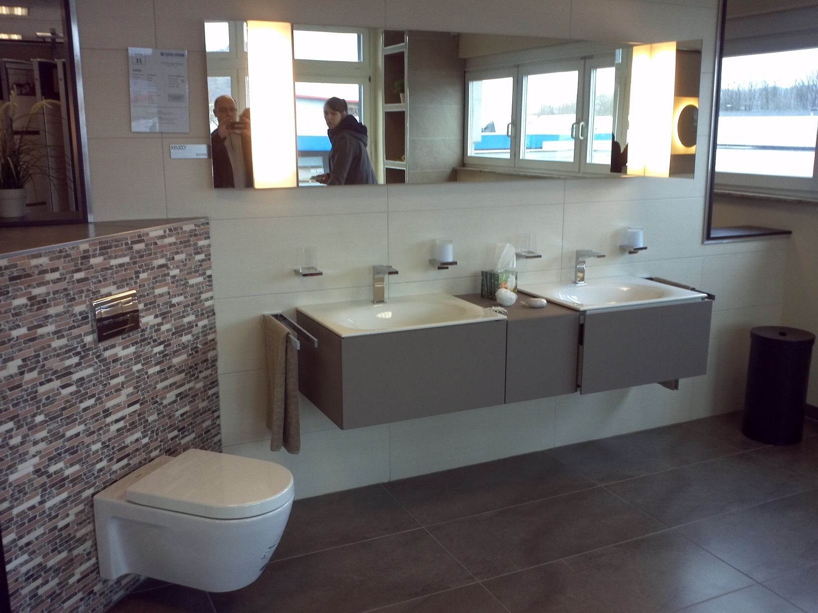 Modernes Badezimmer mit zwei Waschtischen, Spiegeln, grauer Fliesenwand und Toilette