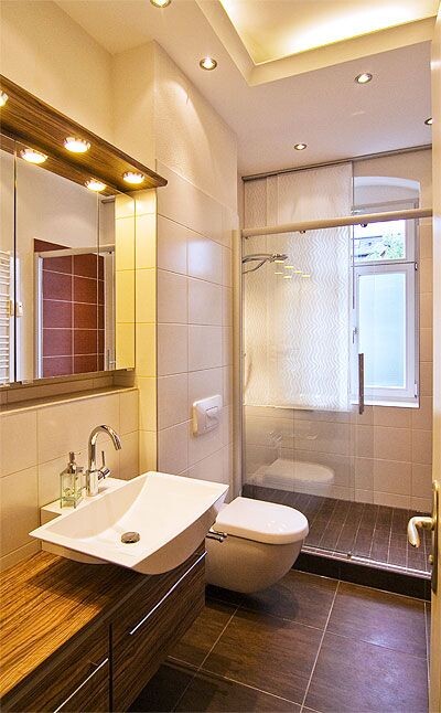 Modernes Badezimmer mit Waschbecken, Toilette und Glasdusche.