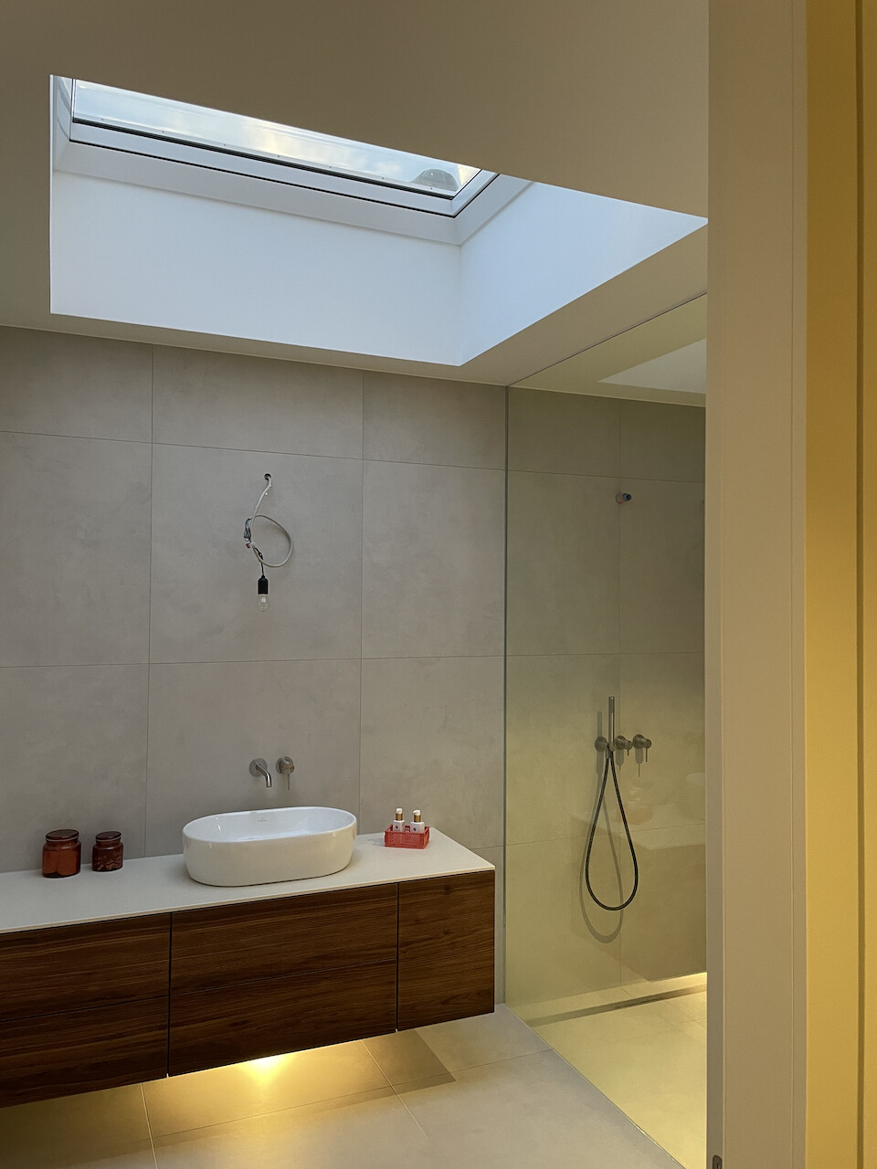 Modernes Badezimmer mit Dachfenster, Wandfliesen, Waschbecken auf Holzunterschrank, Dusche