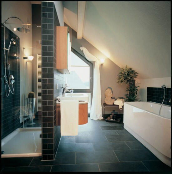 Modernes Badezimmer mit dunklen Fliesen, Dusche, Waschbecken, Badewanne und Fenster.