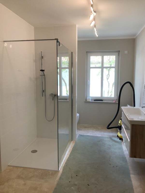 Modernes Badezimmer mit Glasdusche, Fenster und Waschbecken in Bauphase