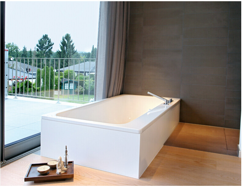 Moderne freistehende Badewanne neben Fenster mit Balkonblick.