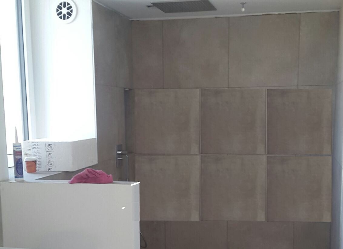 Badezimmer mit beigen Fliesen, Spüle/Unterschrank und Fenster im Bauzustand