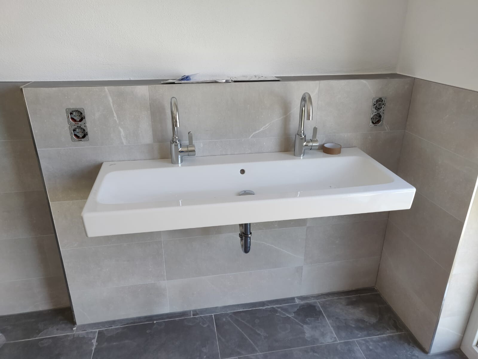 modernes-badezimmer-waschbecken-mit-zweifach-armatur-und-fliesen.jpeg