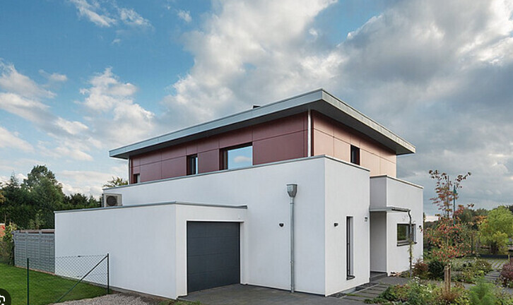 Moderne, zweistöckige weiße Villa mit Garage, Flachdach und Garten.