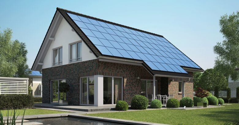 Modernes Einfamilienhaus mit Solarzellen auf dem Dach und gepflegtem Garten.