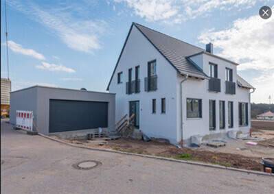 Weißes zweigeschossiges Einfamilienhaus im Bau mit Garage