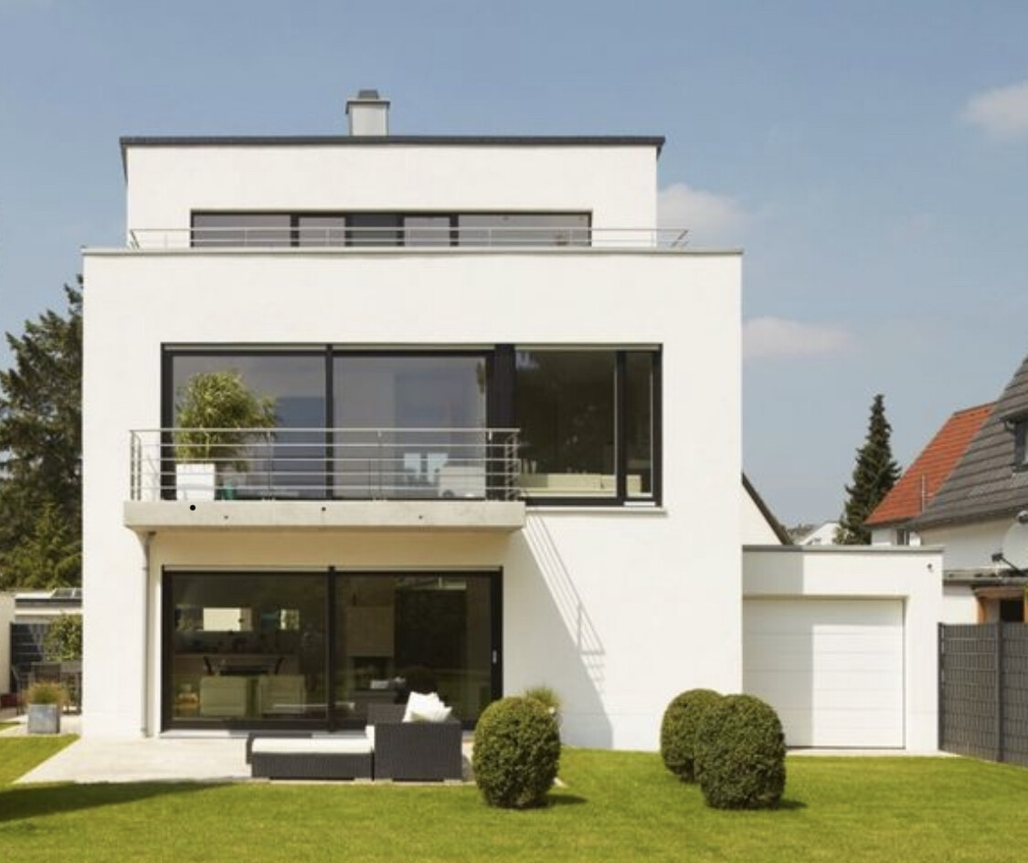 Moderne weiße zweigeschossige Hausfassade mit großen Glasfronten, Terrasse und Garten