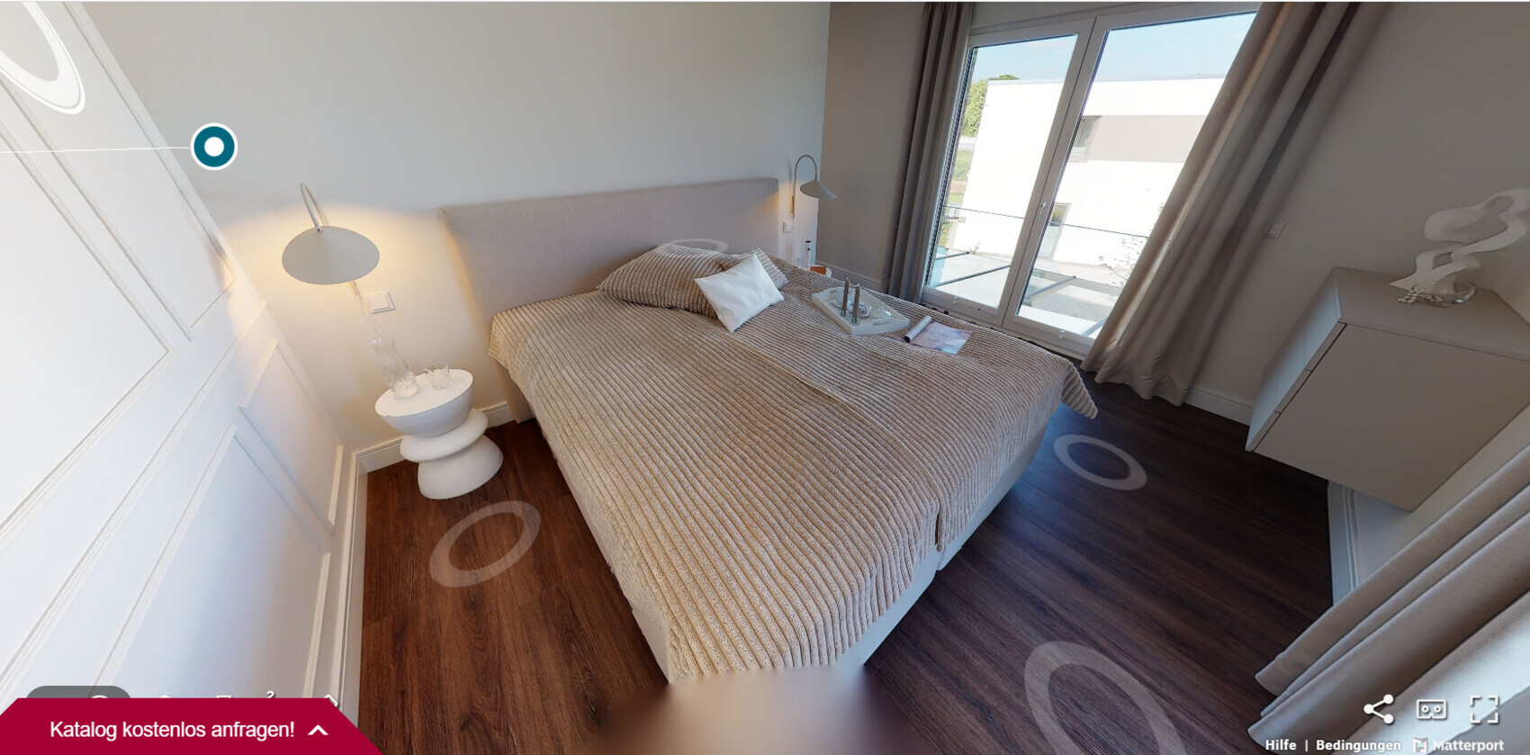 Schlafzimmer mit Bett, beige Decke, Nachttischlampen und Balkonfenster