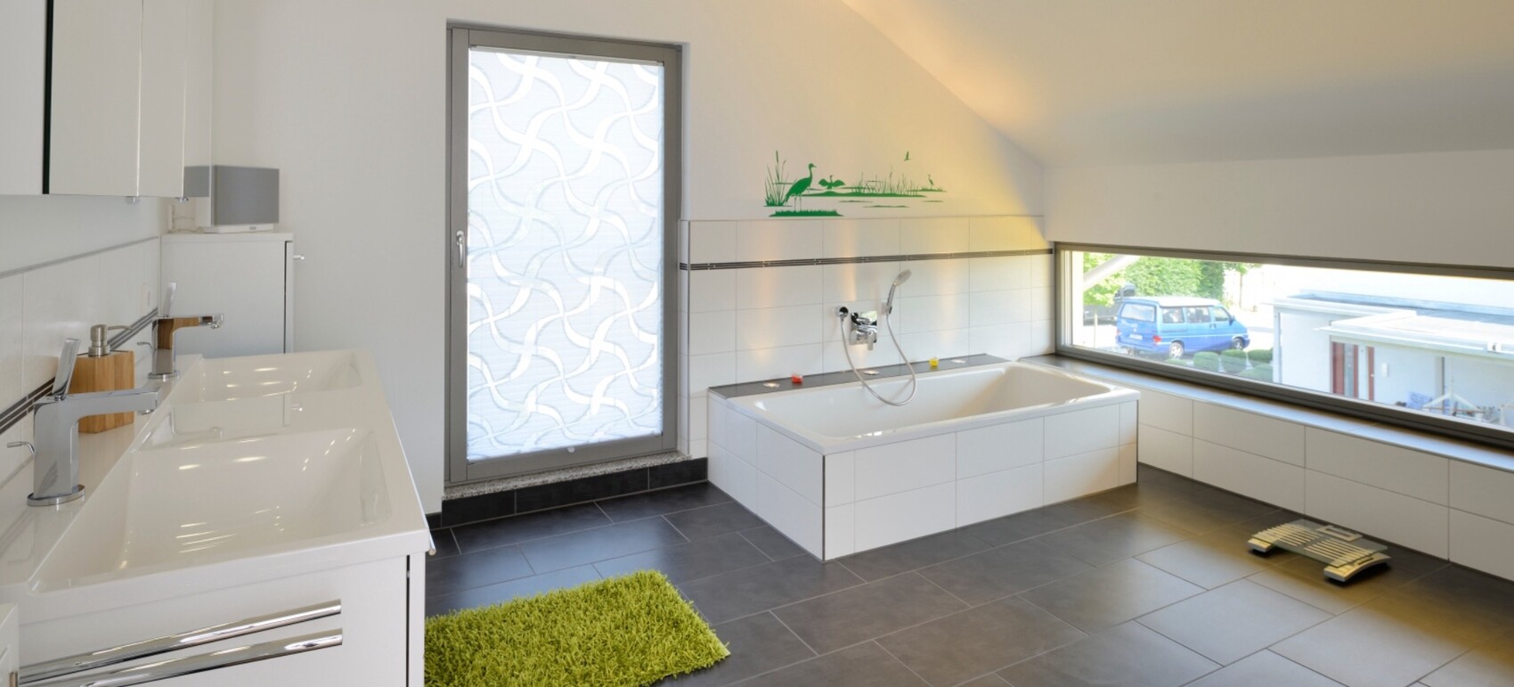 Helles, modernes Badezimmer mit großer Badewanne, Doppelwaschbecken und großer Fensterfront.