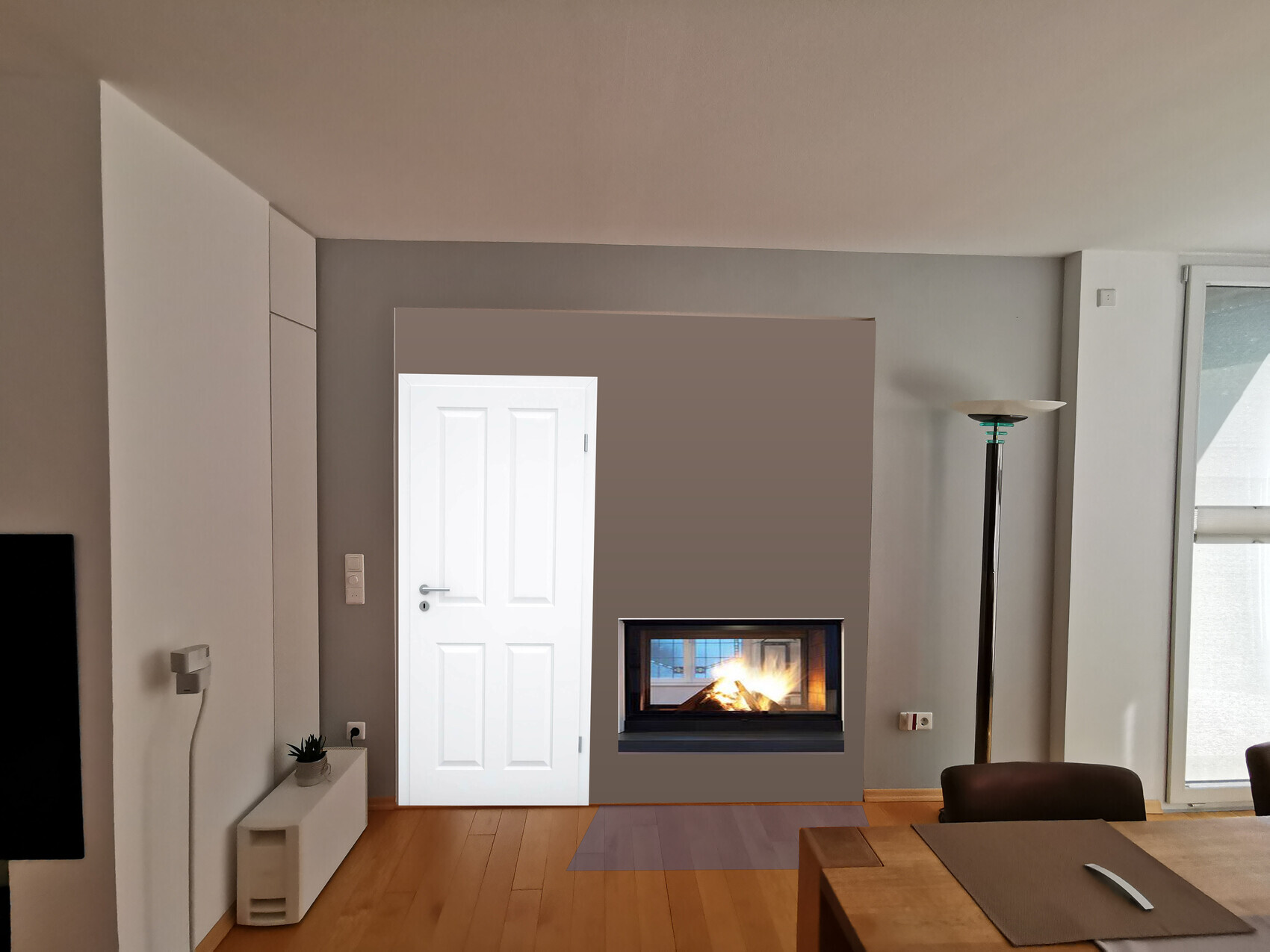 Helles Wohnzimmer, Kamin brennt, weiße Tür links, Stehlampe rechts, Esstisch.