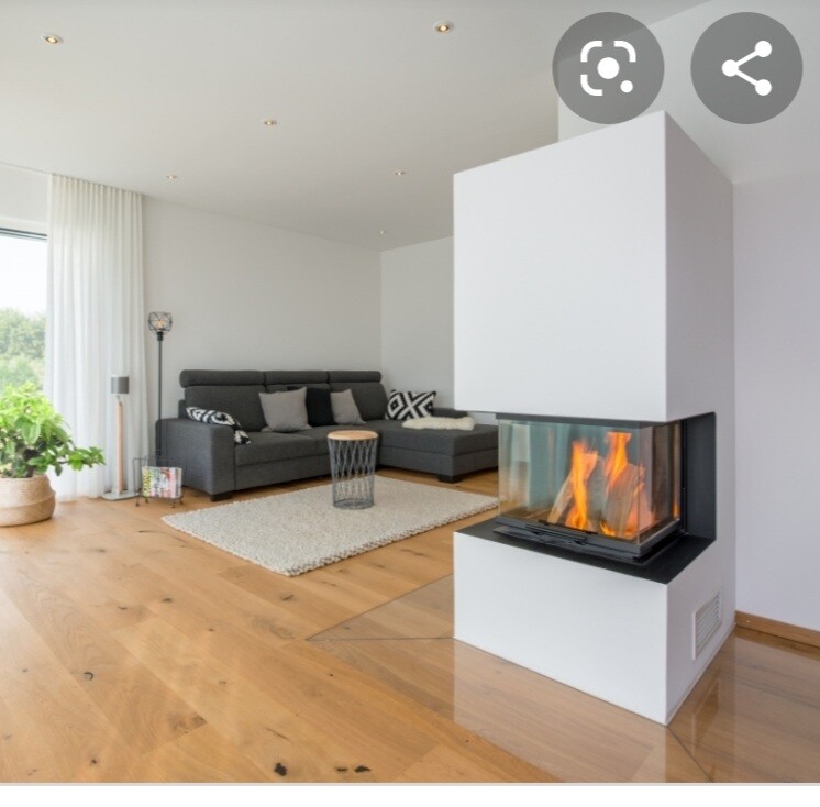 Modernes helles Wohnzimmer mit grauer Eckcouch, Holzboden und weißem Kamin mit Glasfront.