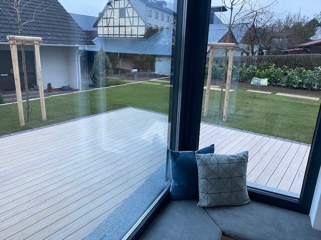 modernes-wohnzimmer-mit-grossen-glasfenstern-und-terrasse.jpg