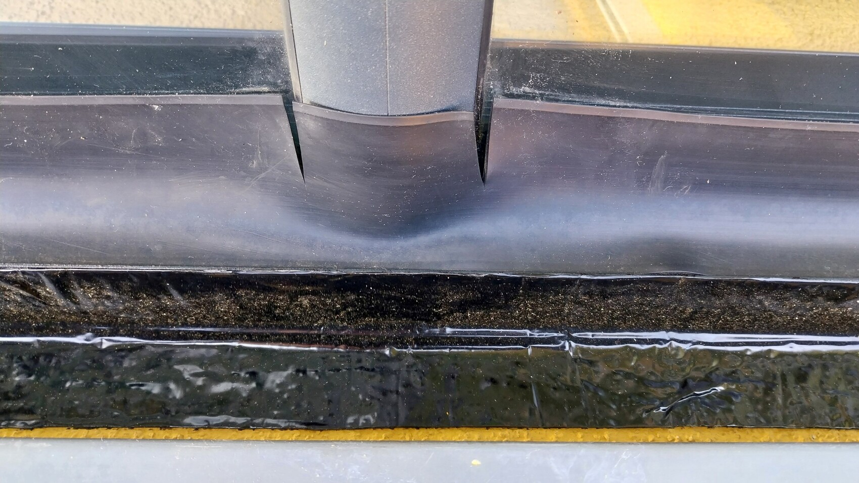 Nahaufnahme eines schwarzen Tür- bzw. Fensterdichtungsprofils am Rahmen mit Spalt