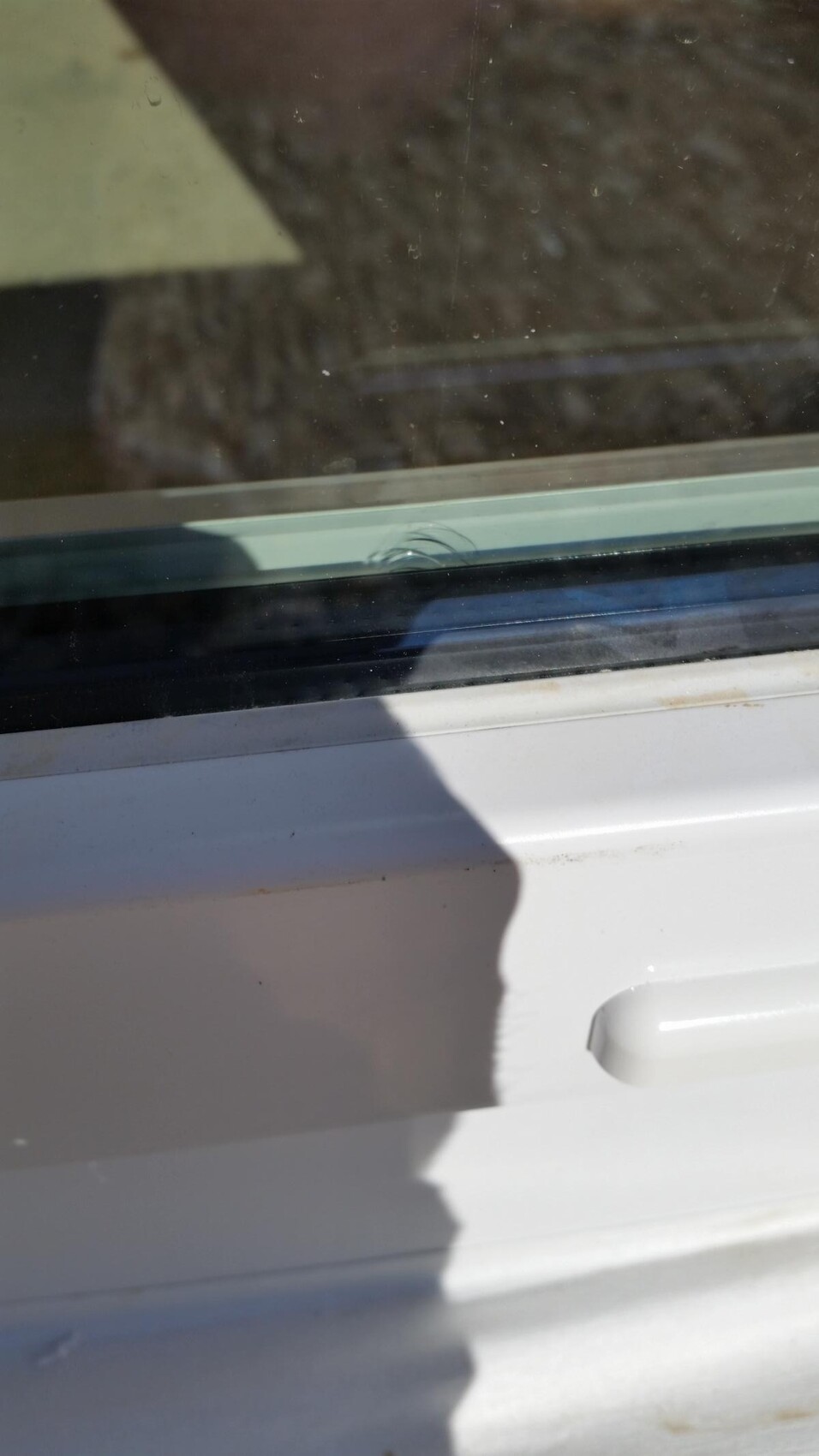 Nahaufnahme eines weißen Fensterrahmens mit Glas und Schatten