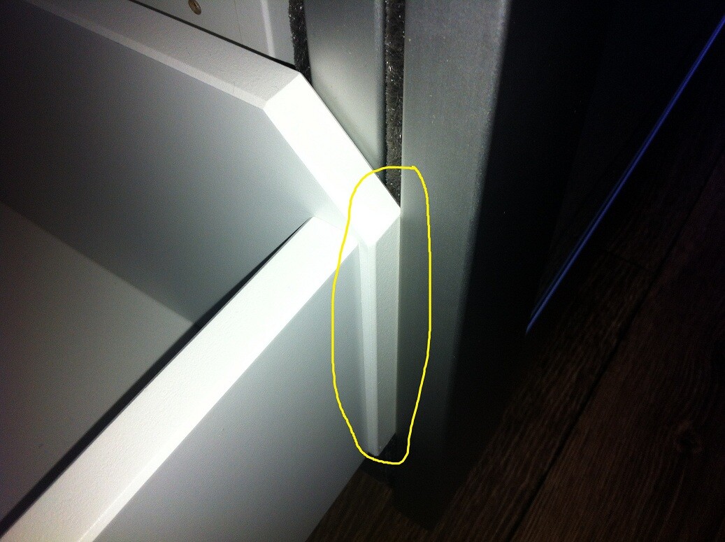 Nahaufnahme eines weißen Möbelstücks; Ecke mit sichtbarem Spalt zwischen Bauteilen.