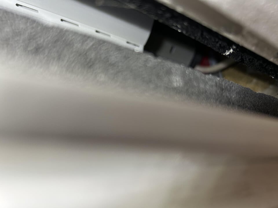 Nahaufnahme eines Metallgehäuses mit drei Lüftungsschlitzen und sichtbaren Kabeln.