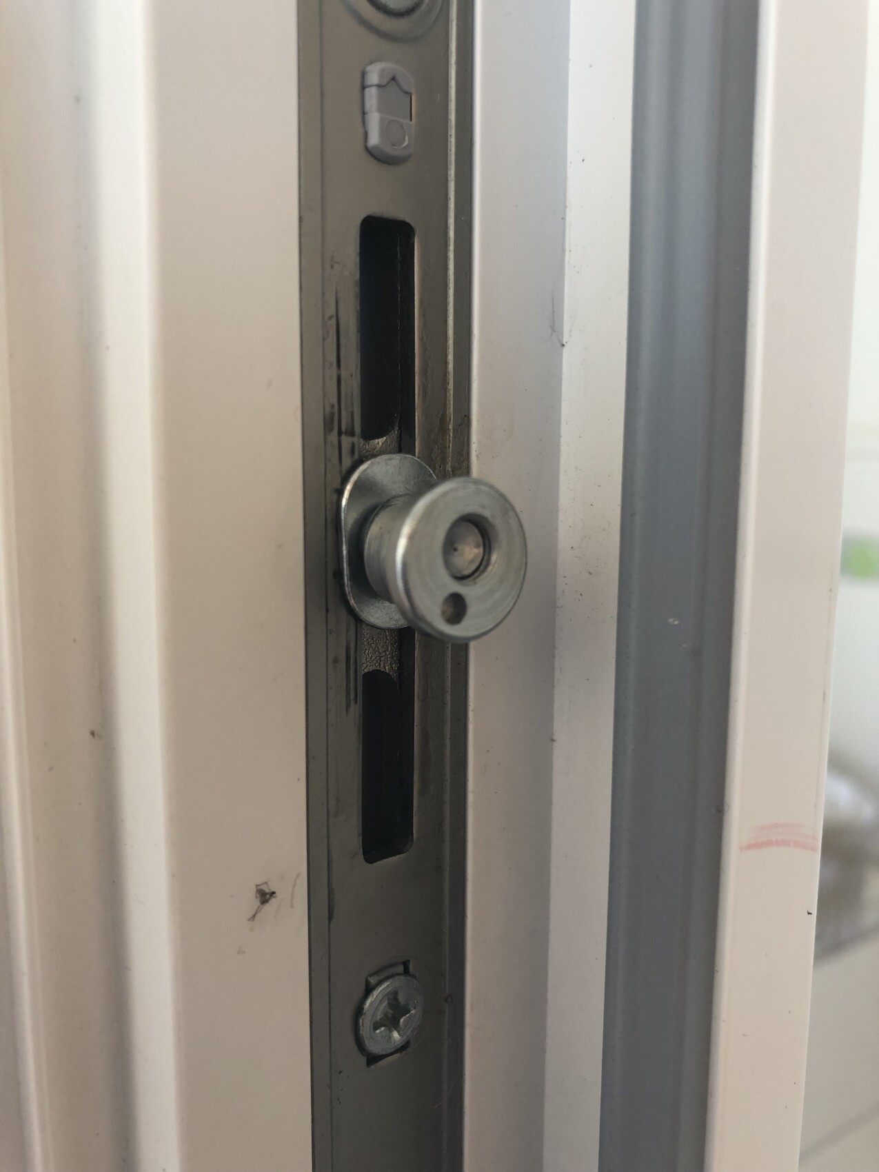 Nahaufnahme einer Türverriegelung im Türrahmen, Metallteil mit Schrauben.