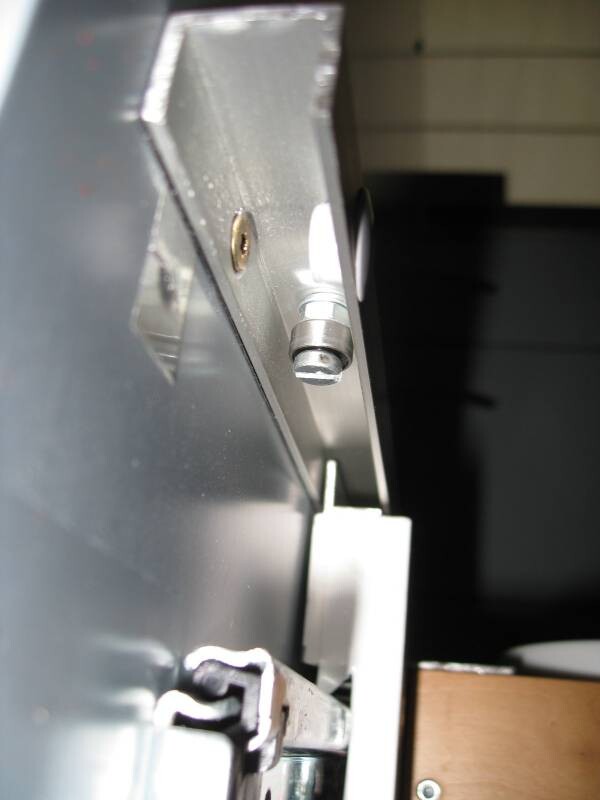 Nahaufnahme einer metallischen Gehäusekante mit Schraube, Bolzen und Halterung.