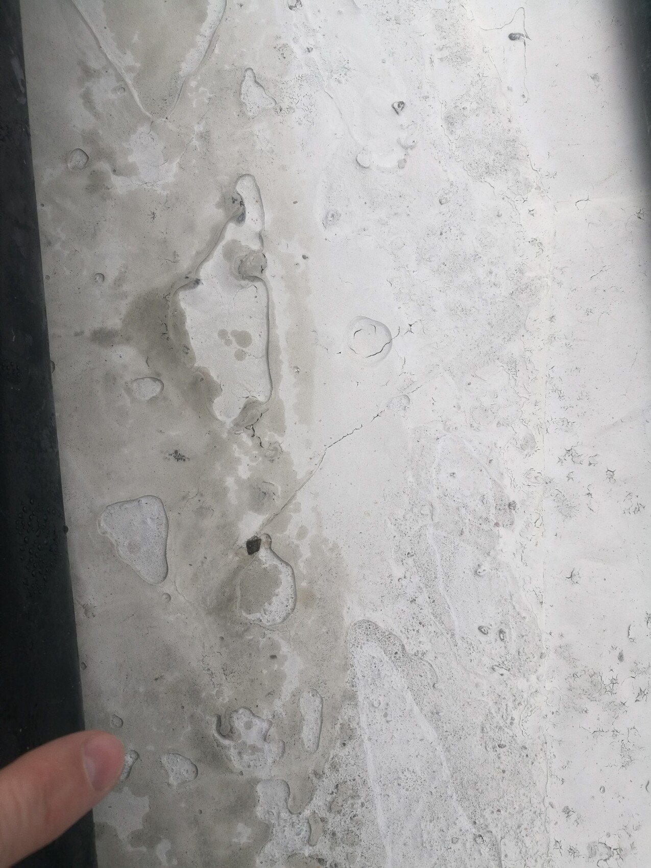 Nasse betonoberflaeche mit wasserpfuetzen und feuchtigkeit