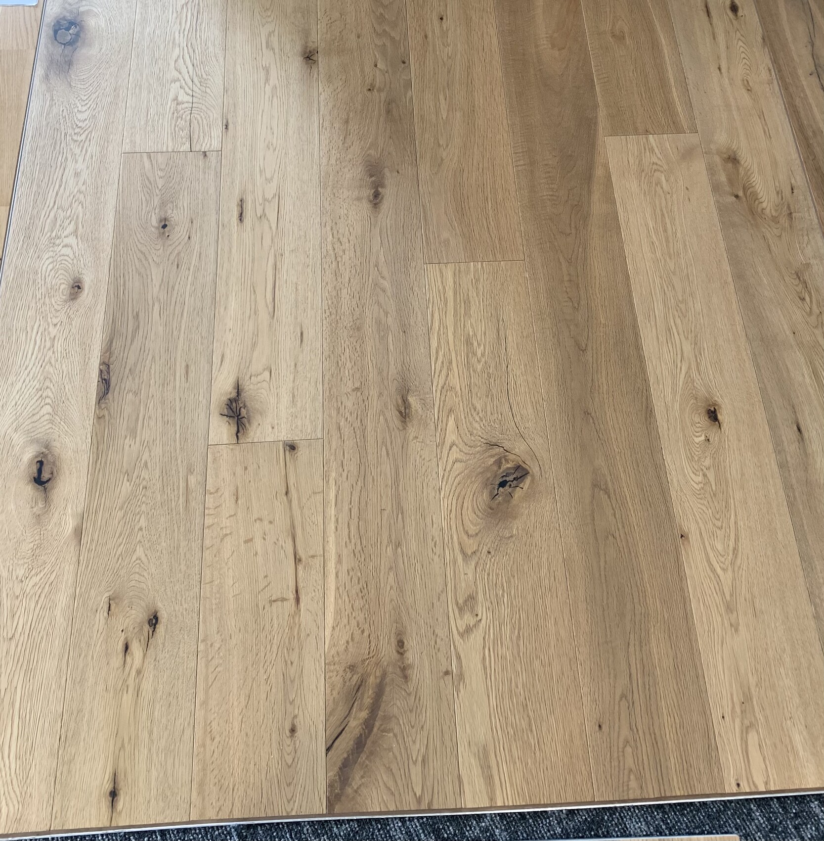 Heller Holzdielenboden aus Eichenholz mit Maserung und Knoten.