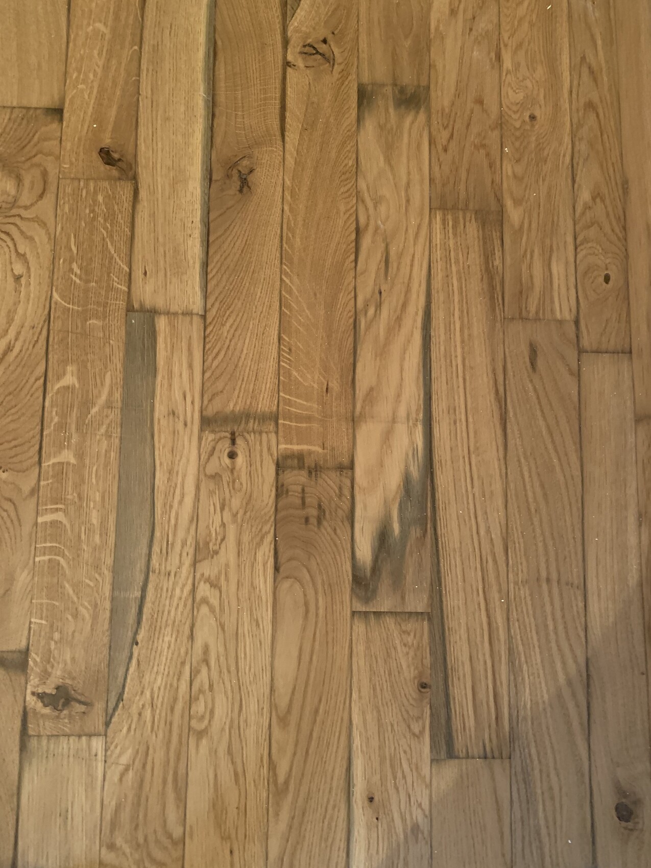 Holzboden mit hellbraunen Holzdielen, sichtbare Maserung und einige Knoten.
