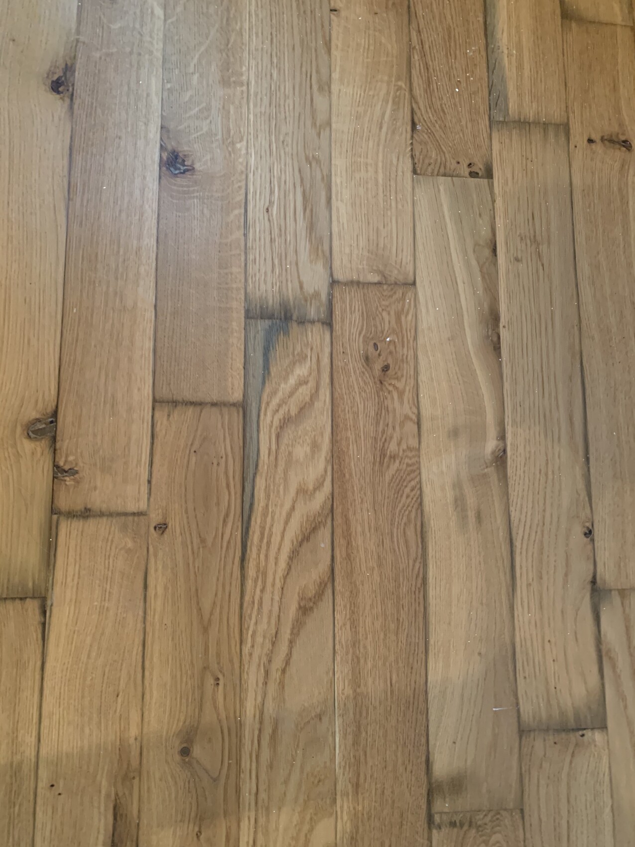 Holzboden aus langen Brettern mit Maserung, Knoten und Farbunterschieden.