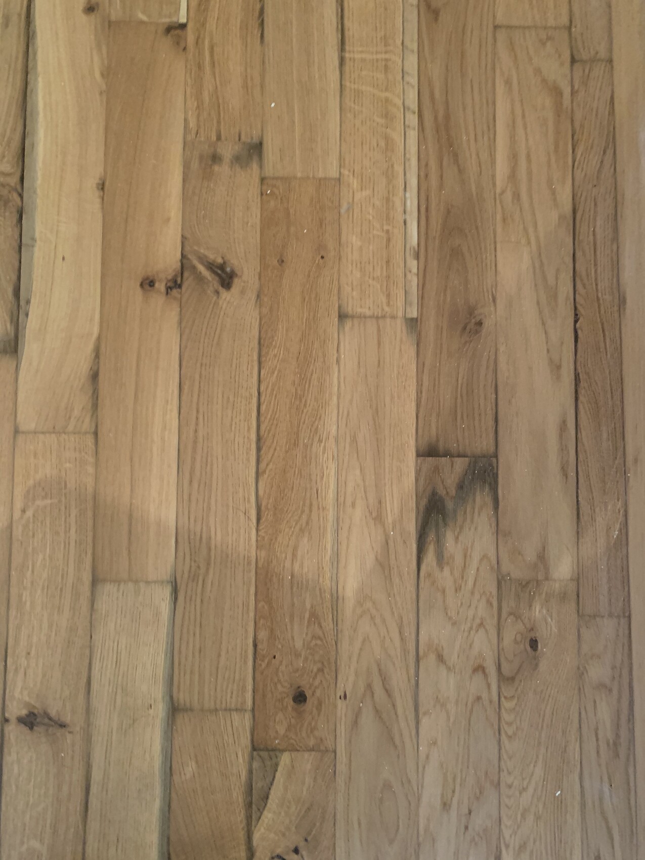 Holzdielenboden in braunen Tönen, sichtbare Maserung und einige Kratzer.