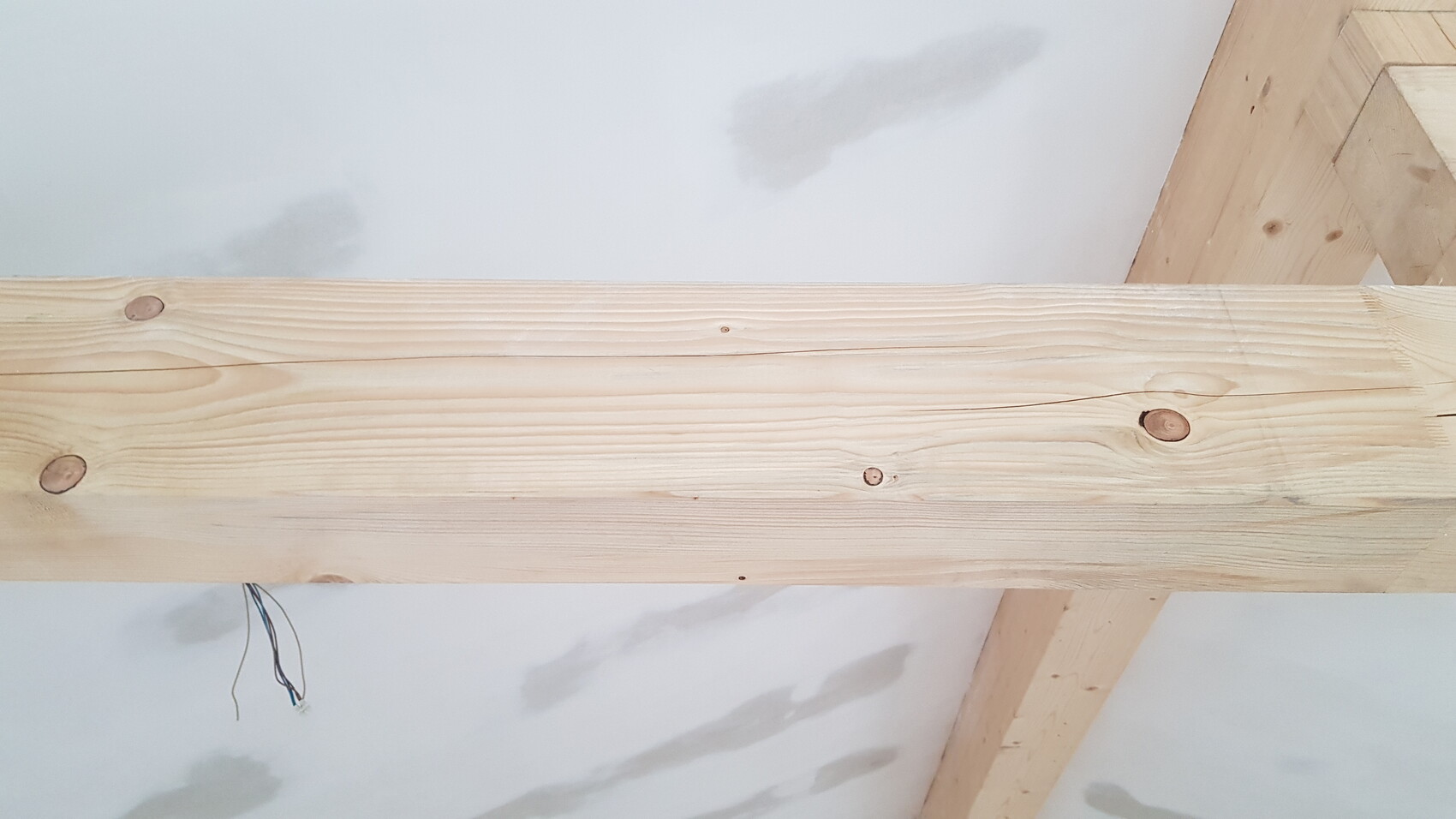Holzbalken als Baustellenträger im Innenausbau mit losen Kabeln
