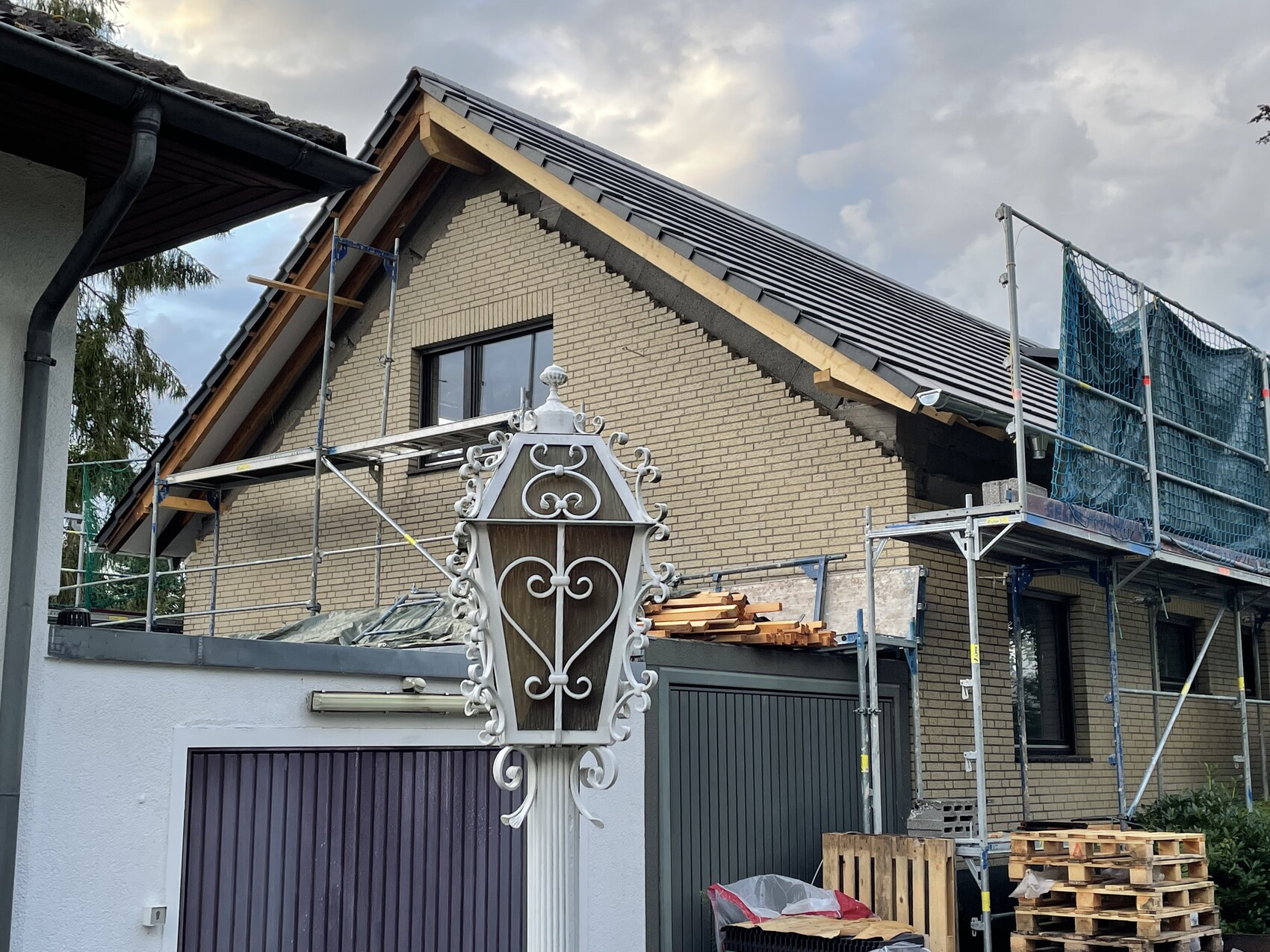 Unter Renovierung stehendes Haus mit Gerüst und einer schmiedeeisernen Straßenlaterne im Vordergrund