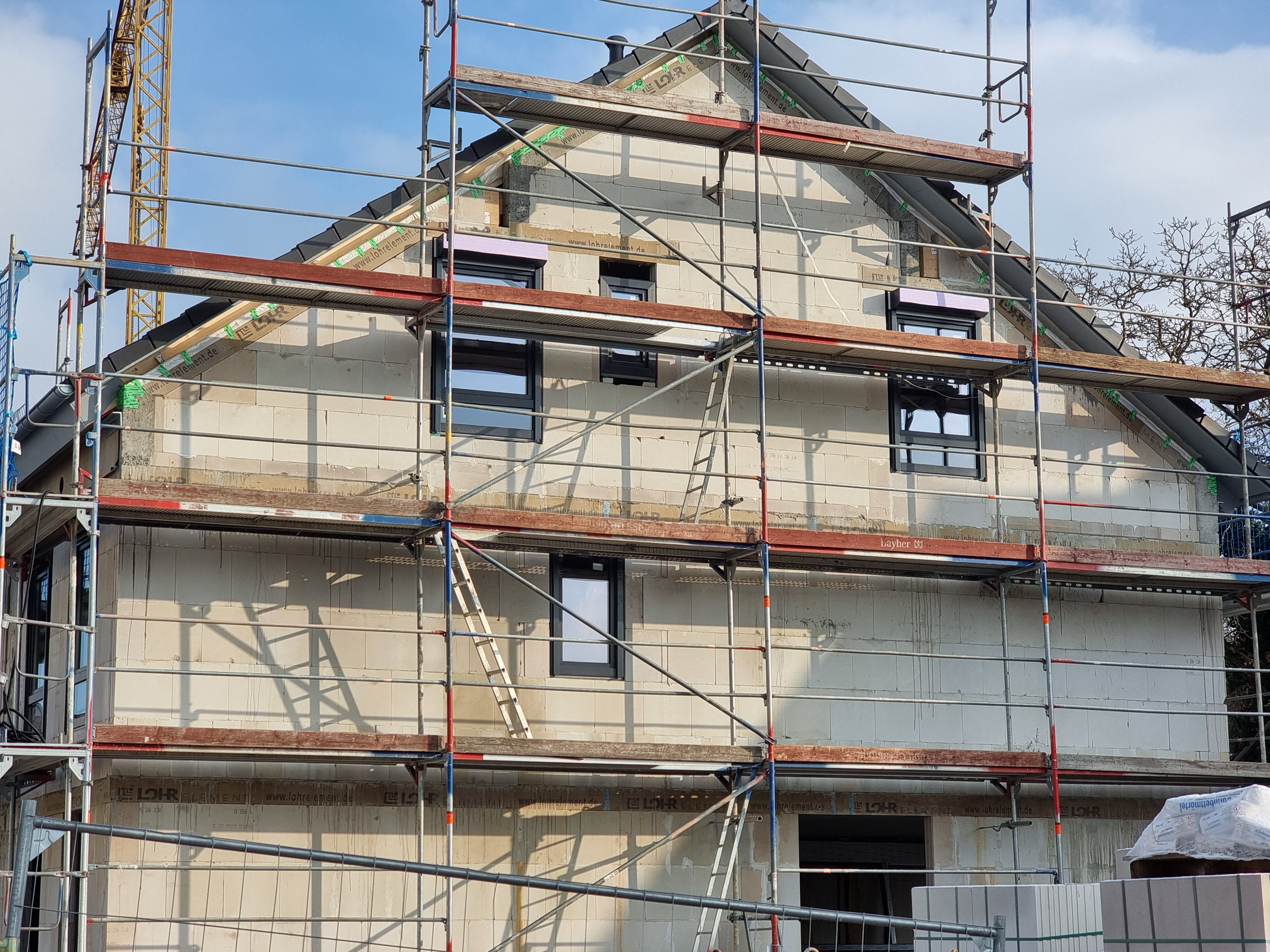 neubau-haus-mit-geruest-aufbau-baustelle.jpg