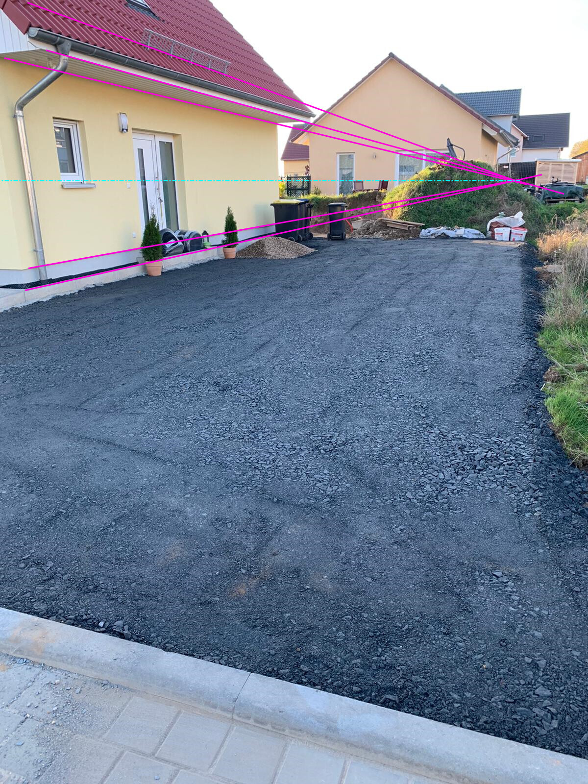Neuer Einfahrtsvorplatz vor gelbem Einfamilienhaus mit Kiesbelag