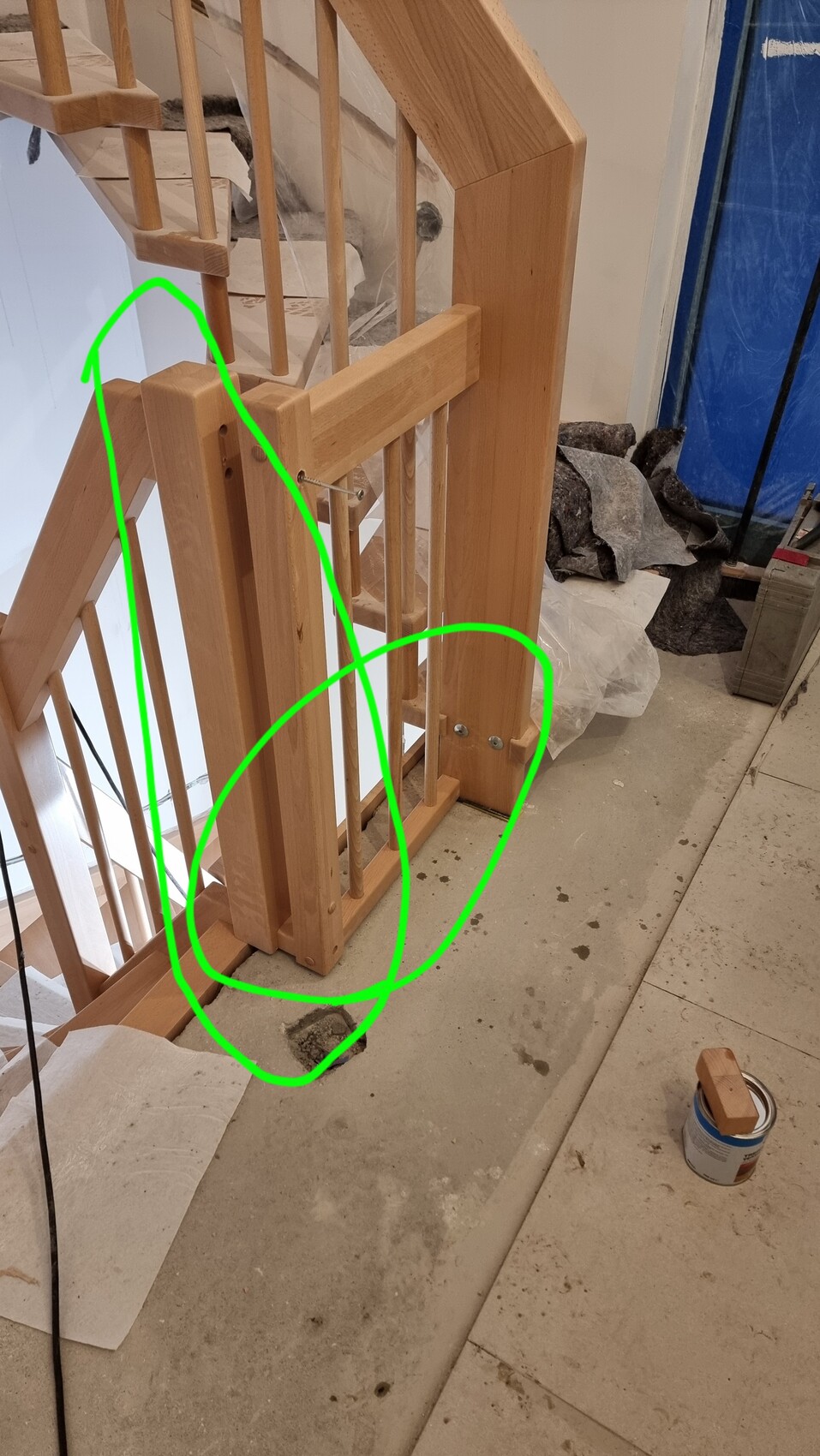 Holztreppe mit Geländer im Bau, Loch im Boden neben Farbdose.