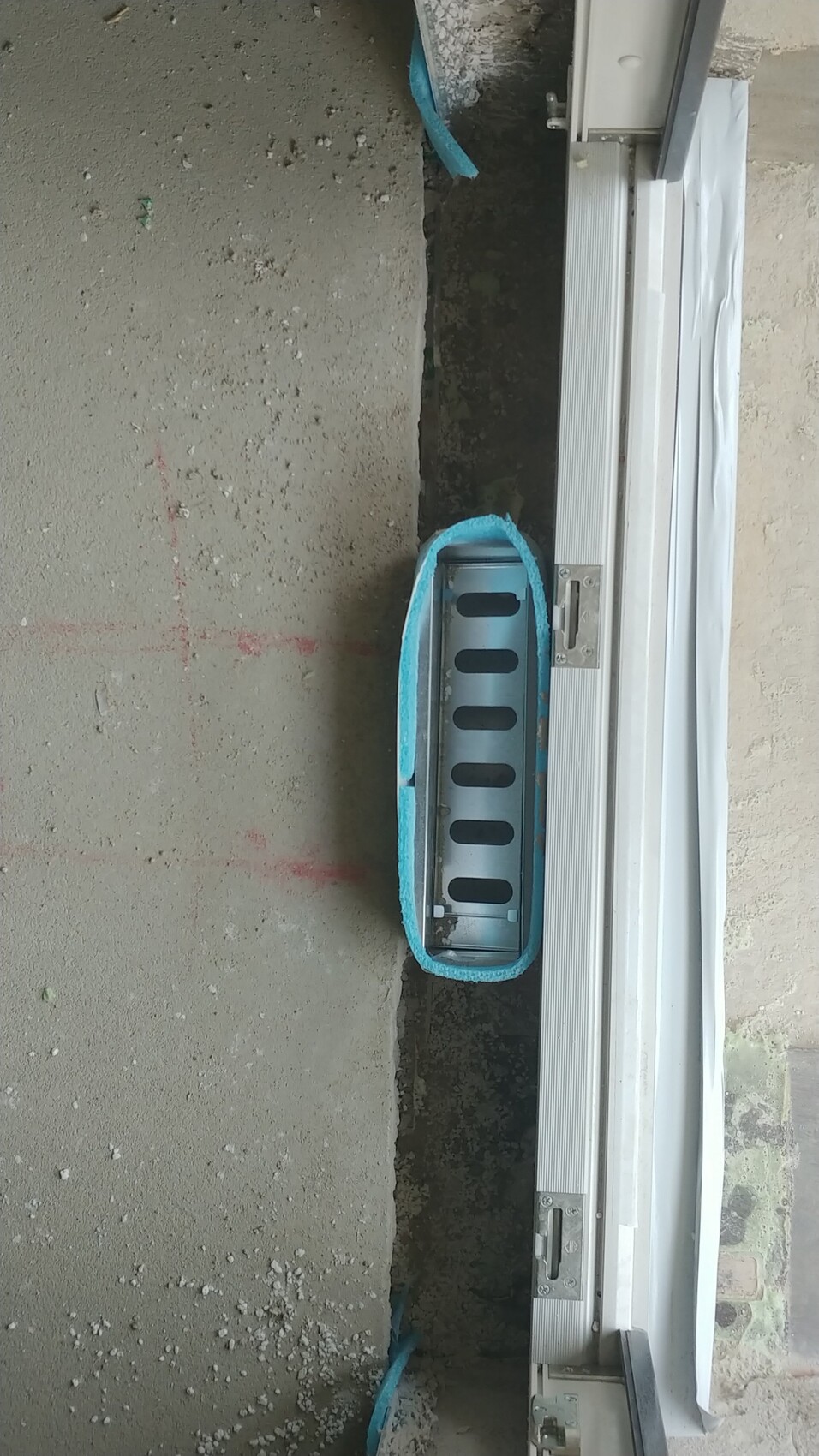Türschwelle mit Metallrahmen und blauer Schutzfolie bei Bauarbeiten