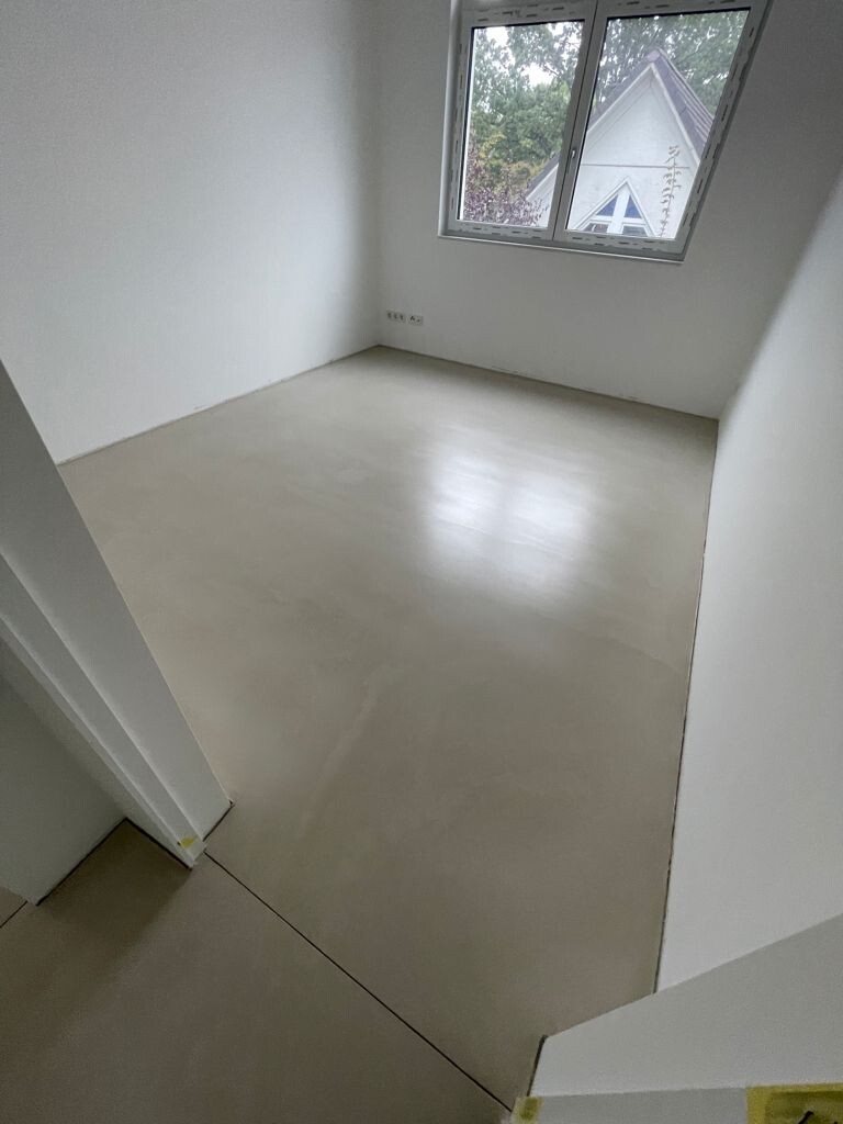 Leerer, heller Raum mit Fenster; weiße Wände, heller Boden.