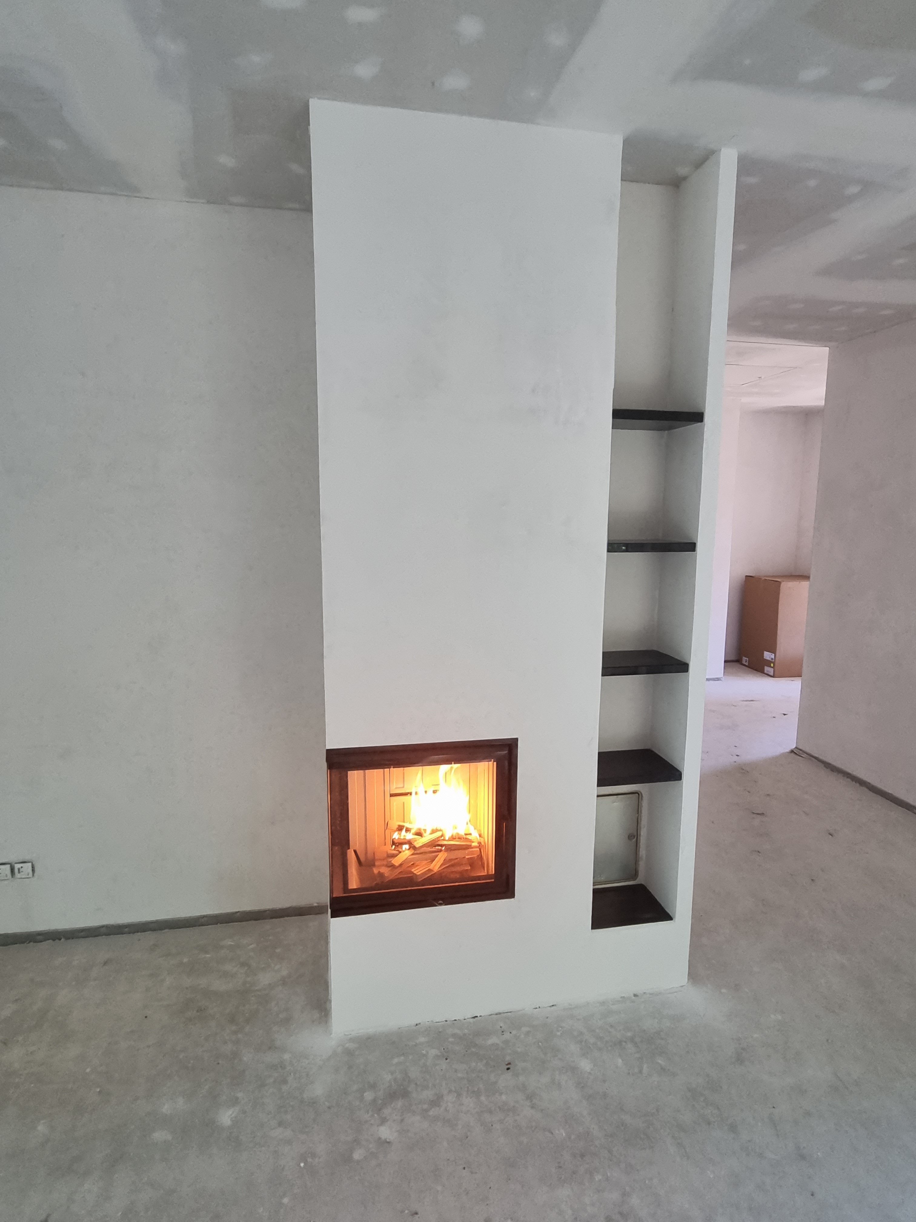 neuer-weisser-wandaufsatz-mit-regalen-kamin-im-wohnraum.jpg