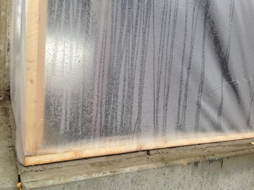 Neues Fensterrahmen-Element mit Schutzfolie auf Betonfundament während Bauphase