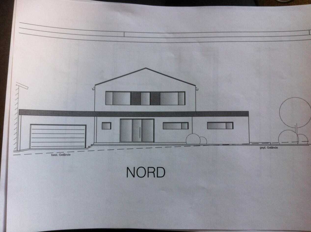 Außenansicht eines modernen, zweigeschossigen Hauses mit Garage und Nordausrichtung