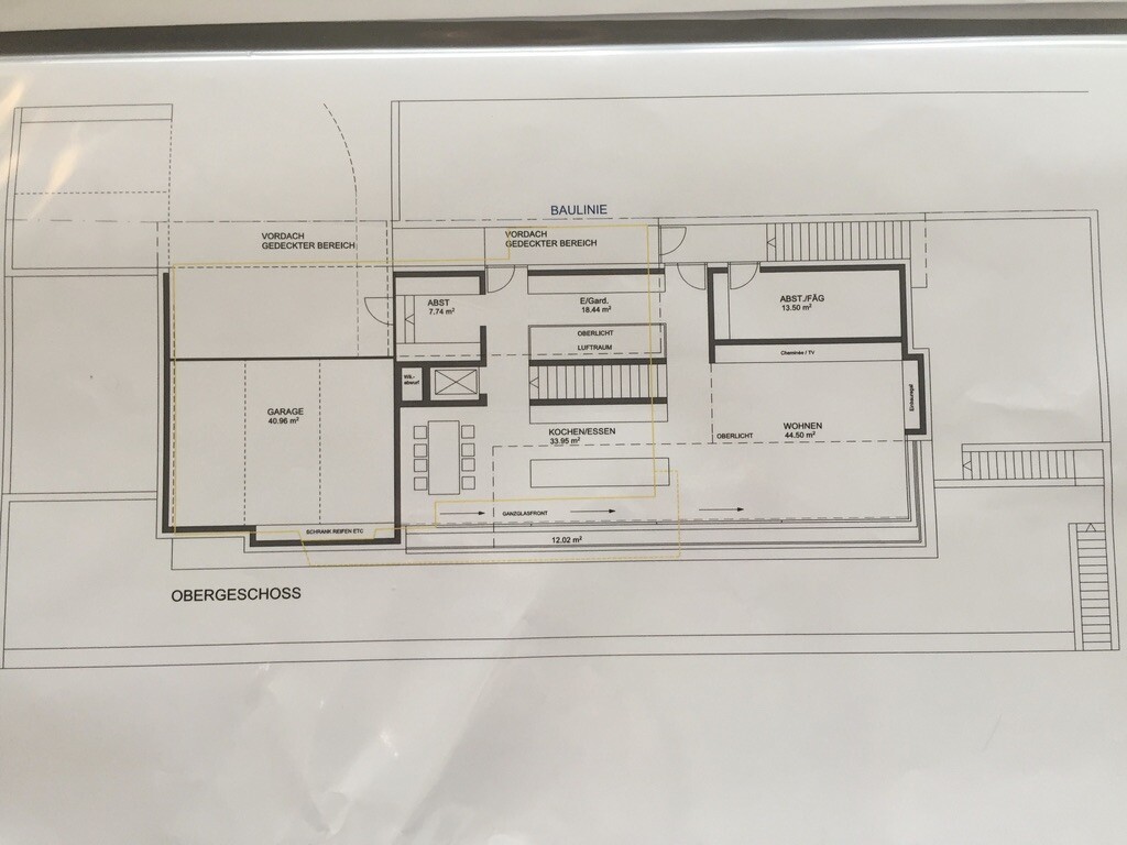 Grundriss des Obergeschosses: Garage, Wohnbereich, Koch-/Essbereich, Abstellräume und Treppen.
