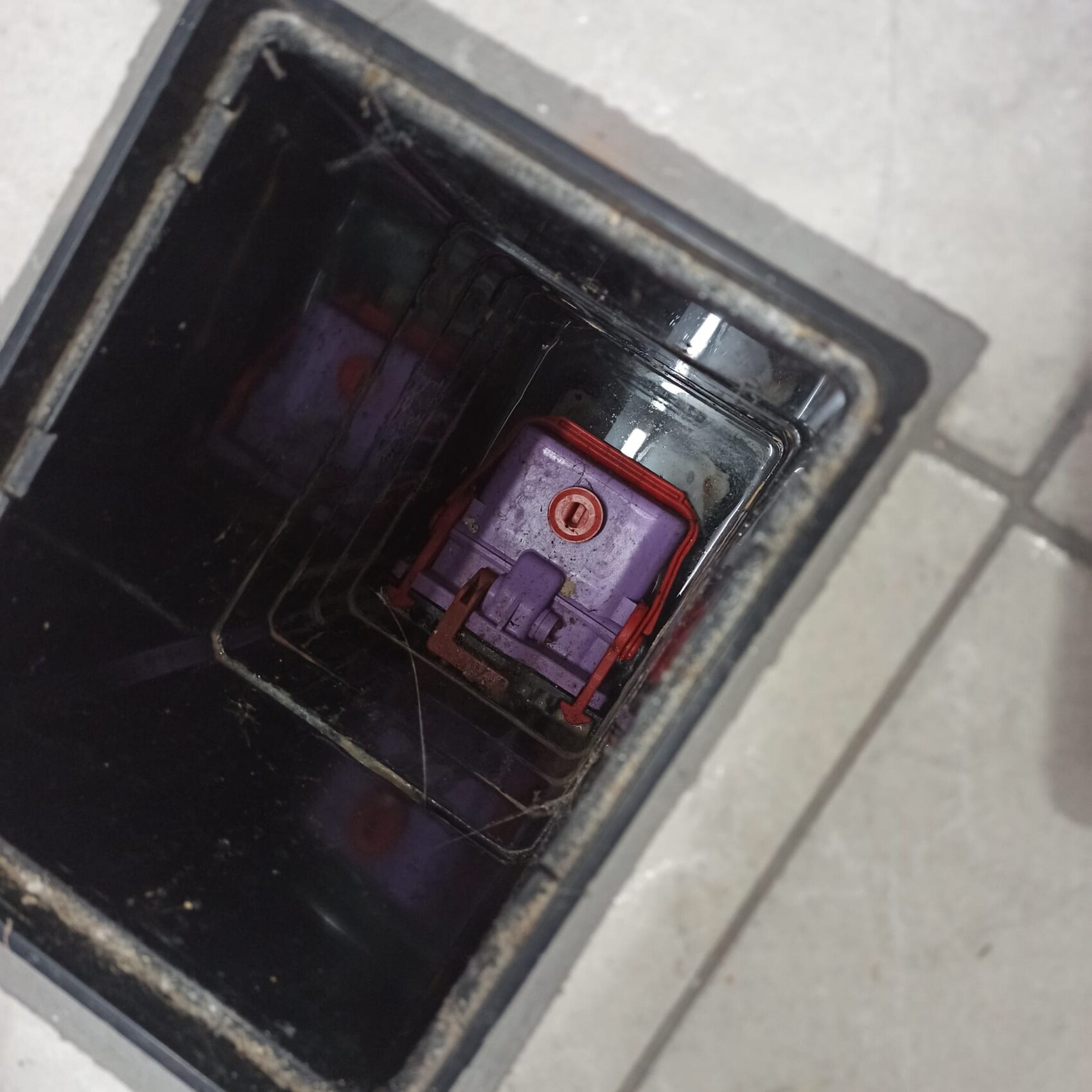 Offener Schacht mit violettem Bauteil und rotem Rahmen im dunklen Innenraum