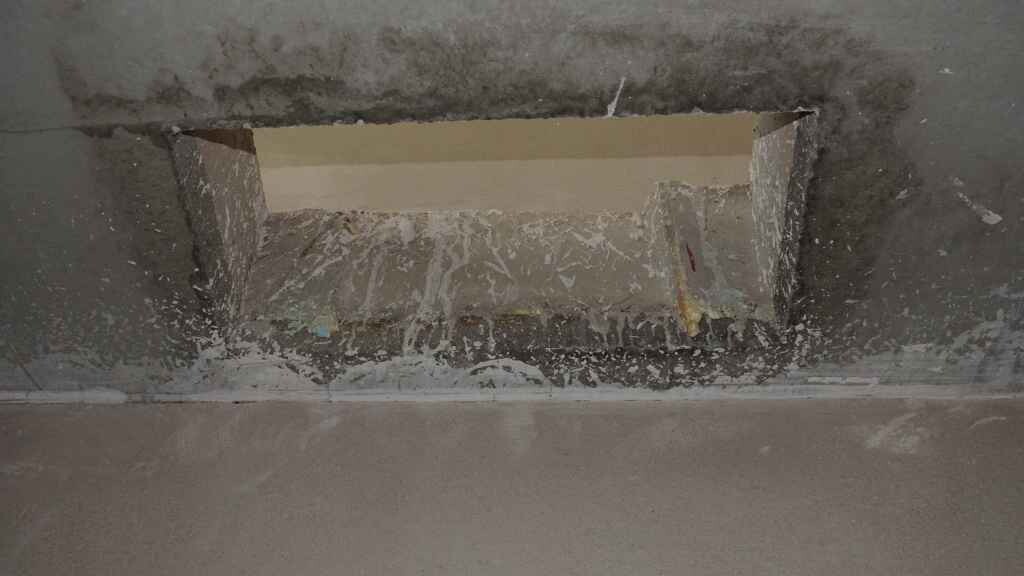 Offene rechteckige Bodenöffnung in rohem Beton, Baustellensituation.