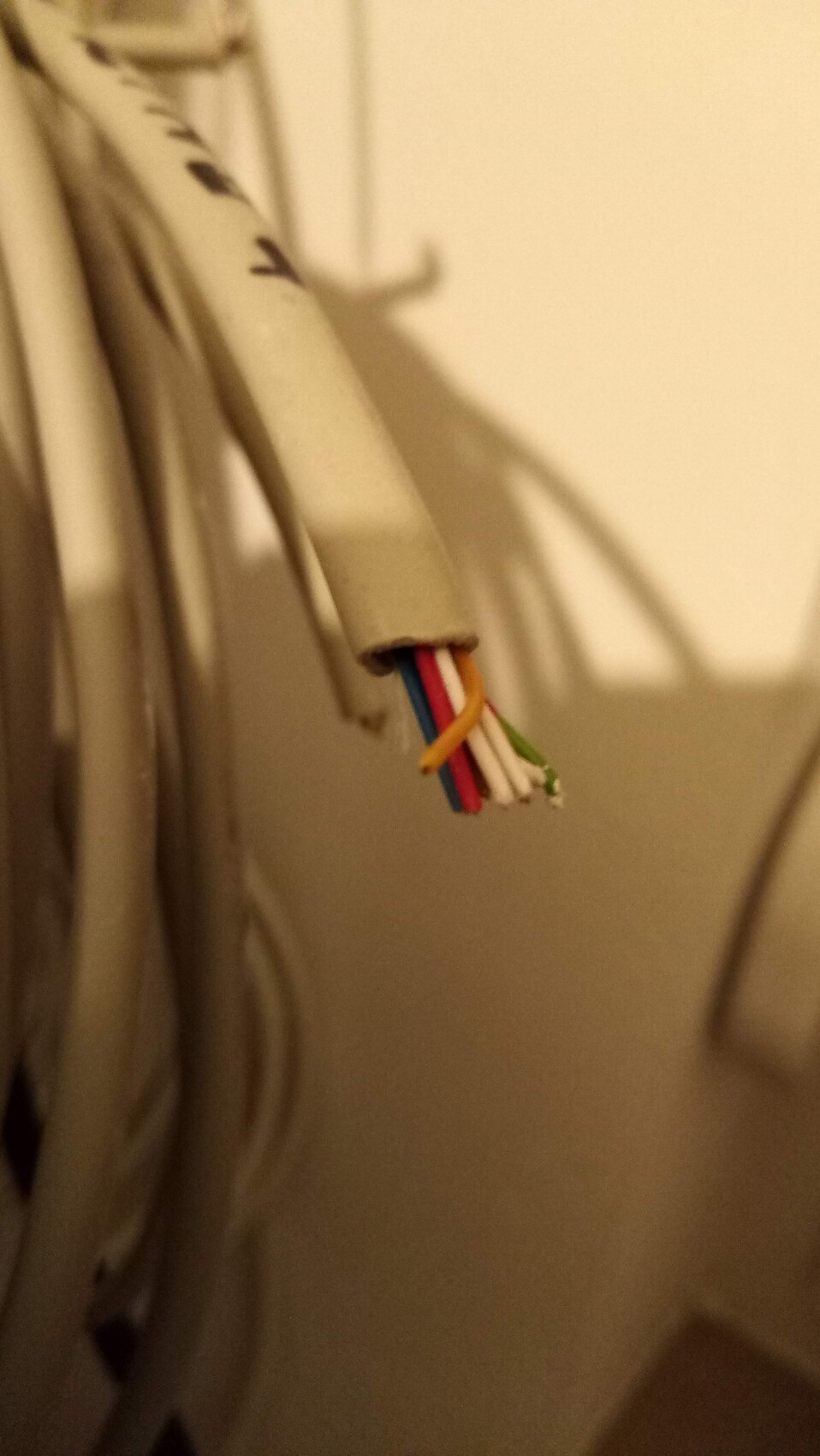 Nahaufnahme offener elektrischer Kabel mit bunten Leitungen in Schutzhülle