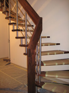 Offene Holztreppe im Innenbereich mit Metallpfosten