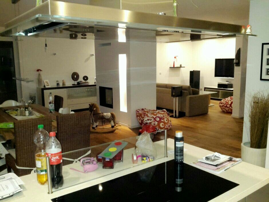 Offene Küche mit Insel, Esstisch und Wohnzimmer im Hintergrund