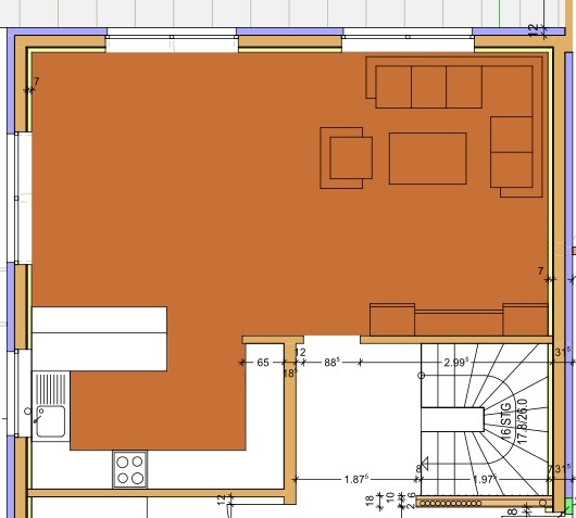 Grundriss eines Wohnraums mit offener Küche links, Sitzecke rechts und Treppe unten rechts.