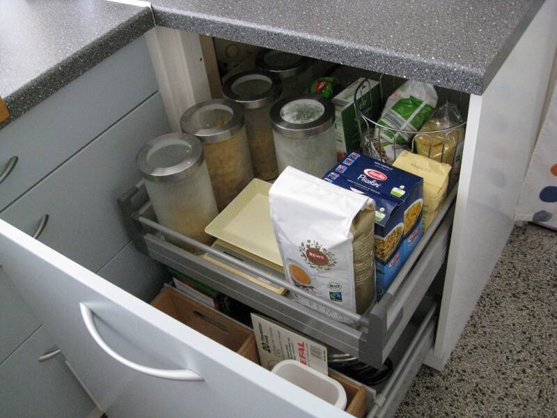 Offene Küchenschublade mit Vorräten wie Mehl, Nudeln und Verpackungen.