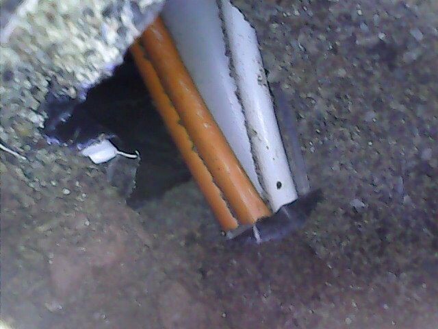 Erdloch mit orangefarbenem und weißem Rohr im Boden.