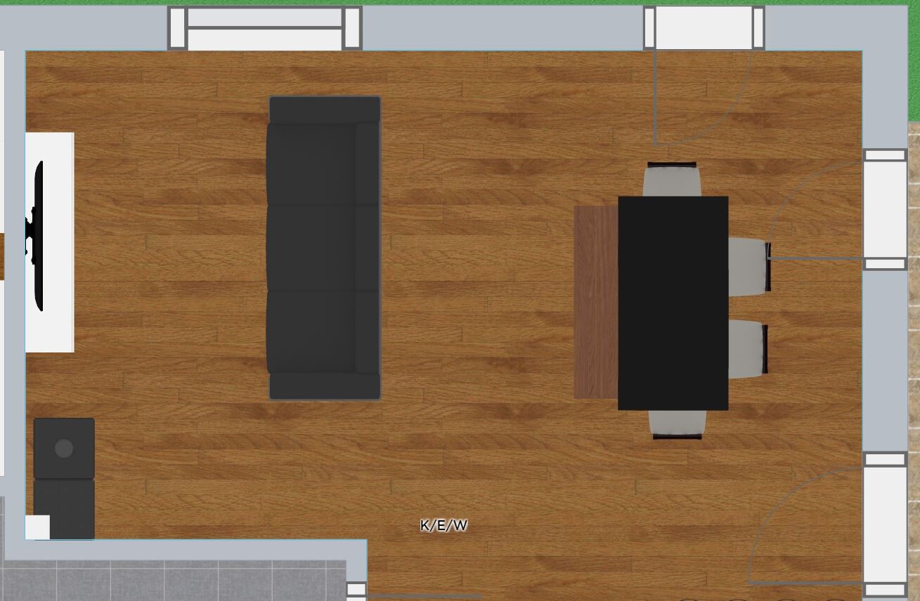 Draufsicht: Wohnzimmer mit Holzboden, schwarzes Sofa, TV links, Esstisch mit Stühlen rechts.